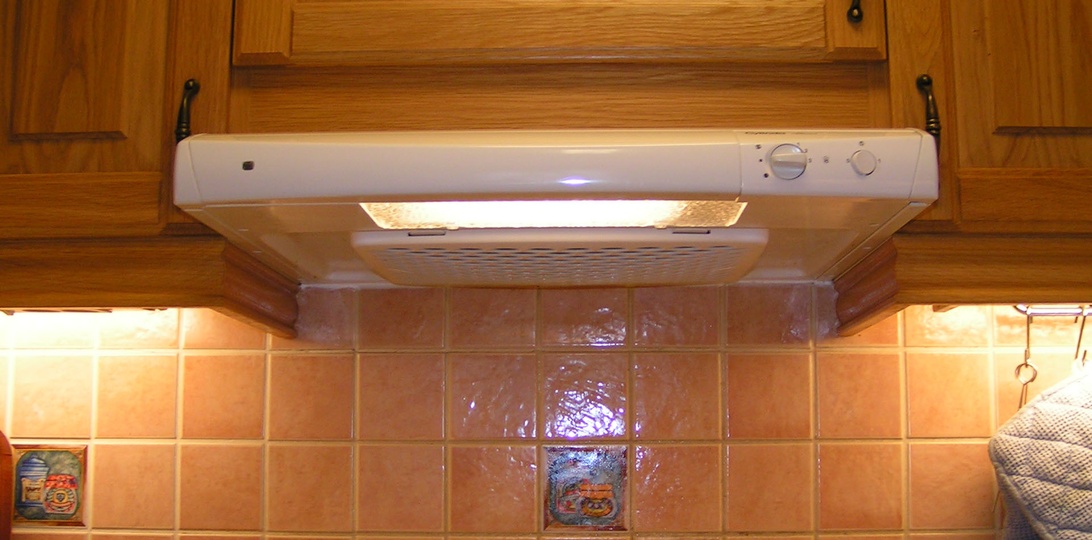 Ett rent och modernt kök med en synlig ventilationsöppning i taket, vilket symboliserar god luftkvalitet.