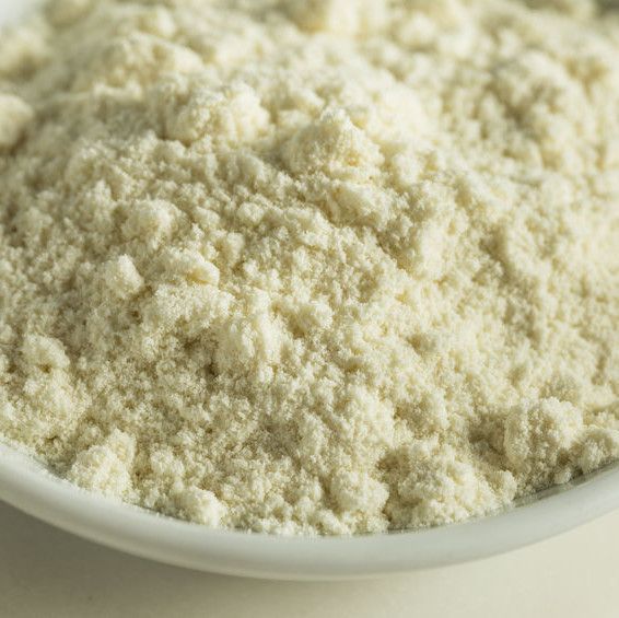 Närbild på fint, vitt proteinpulver i en vit skål.