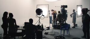 Inspelning i en professionell filmstudio med belysning, kamerautrustning och filmteam.