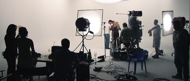 Inspelning i en professionell filmstudio med belysning, kamerautrustning och filmteam.